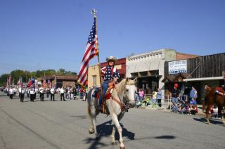 Person on horseback in parade, carrying American flag